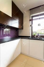 Pictures of purple kitchen design from some of the world's best kitchen makers. Light Kitchen Idea With White And Black Cupboards Dark Worktop Stock Photo Picture And Royalty Free Image Image 60845322