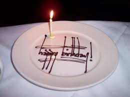Elegant Happy Birthday Cake Wishes Images Elegant Happy Birthday Message Wish Written In Chocolate On A White Plate With A Single Lit Bir 22nd Birthday Cakes Happy Birthday Writing Happy Birthday Cakes