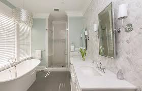 Hang wall art that utilizes a soft color palette composed of cool colors. White And Blue Spa Like Bathroom With Gray Wood Like Floor Tiles Transitional Bathroom
