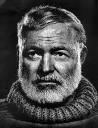 A black and white photo of a man with a beard. Ernest hemingway author  journalist.