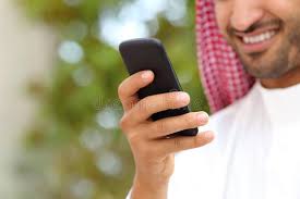 smiling arab saudi man hand using a smart phone outdoor in a park with a green ad man hand saudi smiling arab ad handset new iphone 6 smartphone