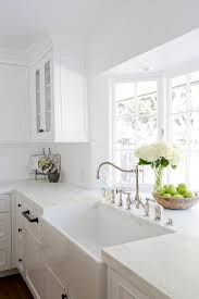 A Gorgeous Farmhouse Sink Is Paired With An Antique Polished Nickel Faucet Mounted In Front Farmhouse Sink Kitchen White Kitchen Design Kitchen Cabinets Decor