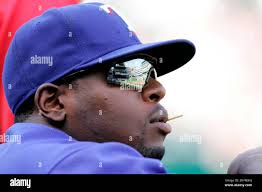 A portion of the Texas Rangers Ballpark in Arlington, is reflected in the  sunglasses of Rangers player Brandon Boggs as he stands in the dugout  during a Major League Baseball game against