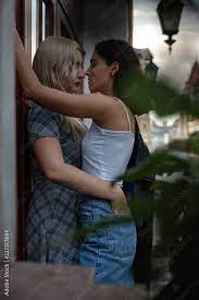Side view image of two erotic lesbians standing at wall. Going to kiss. Non  standard love concept. Stock Photo | Adobe Stock