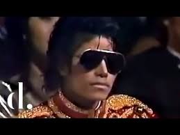 Michael Jackson stares unamused as Barry Manilow sings a tribute medley of  his music at the 1984 AMAs.
