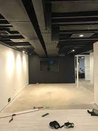 Overall, suspended ceiling tiles could prevent electrical wirings and exposed beams in your basement area. Black Painted Exposed Basement Ceiling Cheap Basement Remodel Exposed Basement Ceiling Basement Lighting