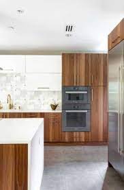 A modern kitchen with white slab front cabinets, chrome hardware and walnut flooring and accents. 17 Walnut Kitchen Cabinet Ideas Sebring Design Build