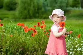 Curly baby with flowers in her hand. Baby With Red Flower Stock Image Colourbox