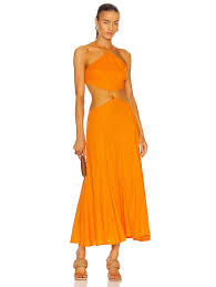 Camila coelho sitting wearing sunglasses, a pink tank top, matching pants, white sandals, and carrying a yellow bag. Cult Gaia Nadeesha Dress In Sunburst Fwrd