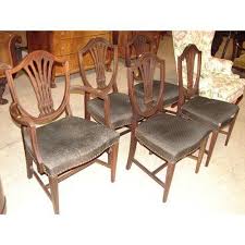 The softly curved shield back is carved in an open vase design that's just a pretty from behind. Hepplewhite Style Shield Back Chairs