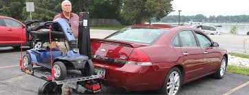 The carrier is mounted on the vehicle hitch and has a ramp to help load the wheelchair. Bruno Chariot Wheelchair Lift Scooter Carrier