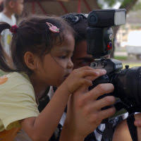 U.S. Air Force 1ST Combat Camera Squadron STAFF SGT. Aaron Allmon, looks  through a camera with a child at the Pattaya Orphanage and School for the  Deaf while deployed during Operation Unified Assistance relief operations  for tsunami victims at ...