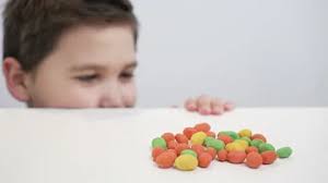 Cheerful boy with mouthful of colorful c...