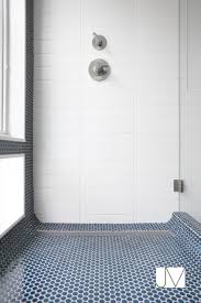 There is a shower tile floor for every budget. White Shower Wall With Navy Pennytile Accent And Floor Tile Small Bathroom Tiles Bathroom Remodel Shower Bathroom Shower Tile
