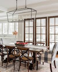 Darlana Linear Lantern Hanging Over A Wood Trestle Dining Table Surrounded By Black And Whit Trestle Dining Tables Solid Oak Dining Table Striped Dining Chairs