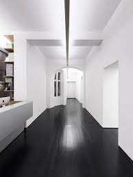 Balancing this expanse of floor, white cabinetry and walls keep the dark wood from overpowering the room and ensure the room stays open and bright. Galerie Berinson Black Wood Floors Dark Wooden Floor White Walls