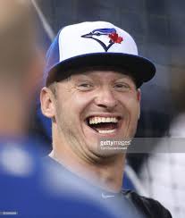 Josh Donaldson of the Toronto Blue Jays laughs as he warms up during...