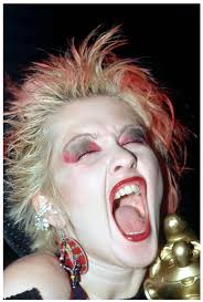Singer Cyndi Lauper in 1980 with a short bleached pixie cut with read  highlights, which she pairs with matching lipstick and eyeshadow. Loved her  🤩♥️
