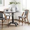 A pair of wicker garden or patio chairs with petal form seats and backs on black painted iron frames and bases. 1