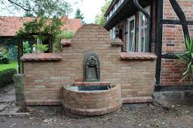 Im vordergrund sind ziegelsteine aufgeschichtet und es ragt eine wand eines von den sanden der zeit zugewehten altbabylonischen hauses hervor, weiter sind ebenso akkurat. Alte Ziegelsteine