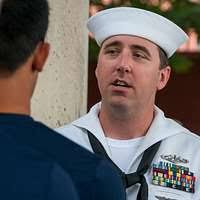 Culinary Specialist 1st Class Joshua Conrad, a recruiter at Navy Recruiting  District St. Louis, speaks with Delayed Entry Program participants prior to  entering Busch Stadium for a joint oath of enlistment ceremony. -
