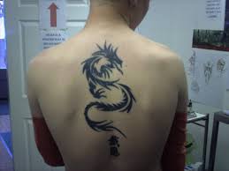 Plus, your back piece tattoo can be one small and simple drawing, an awesome big and intricate concept, or a breathtaking image or collage of art that takes up the full back. Black Spiral Tribal Dragon Tattoo On Upper Half Back