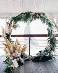 But for weddings and home decor, where it's reigning as one of the biggest trends, pampas grass is used in wedding bouquets, centerpiece arrangements, and as part of dried floral arrangements at the ends of ceremony aisles. Pampas Grass Wedding Trend 2018 Cheap Flower Alternative Floral Wreath Wedding Cheap Wedding Flowers Wedding Arch