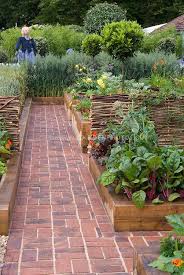 Brick Path Through Beautiful Raised Bed Vegetable Gardens Wheat Growing Along The Edge Willow Fence Planting Flowers Backyard Beautiful Gardens