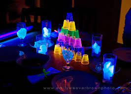 It's at this girl's house, and they removed all the furniture from their living room, and they blacked out alllll the windows and walls. Blacklight Dinner Blog Emily Weaver Brown Blacklight Party Halloween Lights Decorations Party Tableware