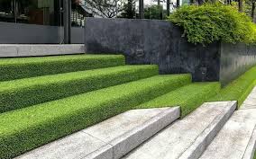 Rolling out the fake grass over surface. Grass For Landscapes Artificial Turf For Landscapes