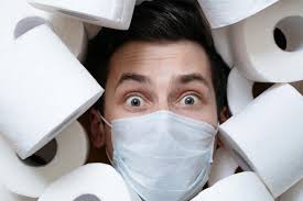 Primer plano de un hombre con ojos asustados en una mascarilla médica  protectora rodeada de papel