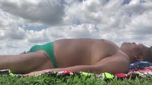 Prendre un bain de soleil au parc de Bayonne en bikini vert