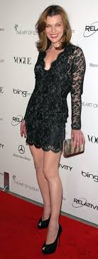 Julia was in the big chair by the fireplace, looking plumper than usual in her new green dress. Milla Jovovich Height How Tall