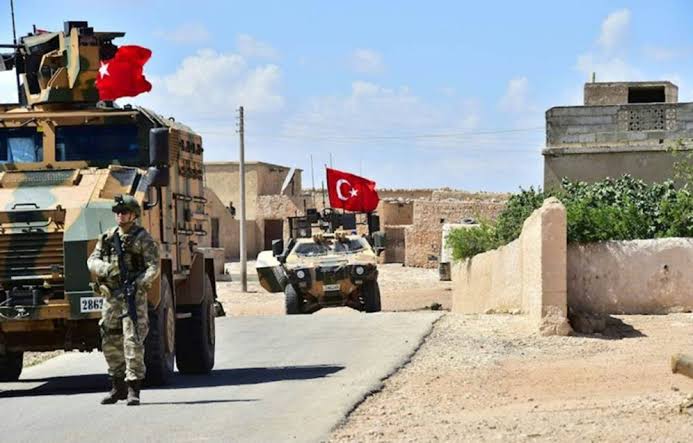 Soldats et véhicules militaires patrouillant dans une zone désertique