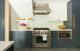 White And Blue Kitchen Boasts White Upper Cabinets And Dark Blue Lower Cabinets Adorned With Bra Kitchen Backsplash Trends Blue Kitchen Designs Kitchen Remodel