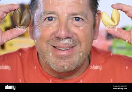 Hessisch Oldendorf, Germany. 15th Aug, 2024. Michael Rohrdrommel, founder  of Happykeks GmbH, shows a brown cocoa fortune cookie and a  vanilla-flavored fortune cookie. The start-up from Lower Saxony now sells  more than