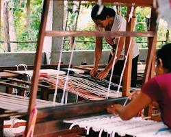 Cambodian woman weaving on a traditional wooden loom