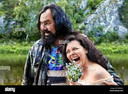 Unkempt, shaggy older male embraces of laughing middle-aged woman. Cheerful  couple from rural areas poses for a photograph in nature, a hairy man and  Stock Photo - Alamy