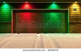 Multi Colored Garage Door And Snowy Driveway Red Green And Yellow Lights Decorate The Front Of A Garage Garage Doors Garage Makeover Garage Door Maintenance