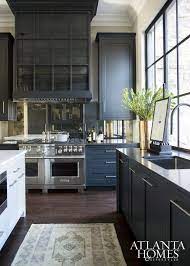 Blue tile kitchen interior with wooden countertops and cabinets, a red cooking pot and several potted plants. Blue Blue Kitchen Black Kitchen Cabinets Kitchen Cabinet Design Navy Kitchen Cabinets