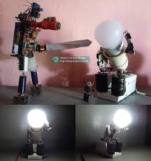 Patung ini adalah hasil karya jason lee, seorang seniman dari inggris dan ini hanyalah salah satu dari beberapa karyanya yang kesemuanya terbuat dari besi bekas. Hiasan Tempat Lampu Bentuk Robot Dari Barang Bekas
