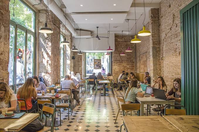 People working from a laptop-friendly cafe