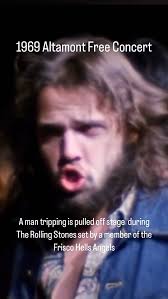 A man tripping balls is pulled off stage during The Rolling Stones set by a  member of the Frisco Hells Angels during the December 6th, 1969 Free  Altamont Concert.