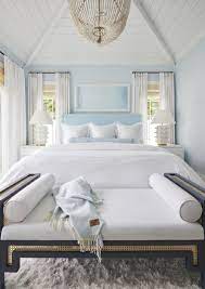 The upholstered headboard features geometric stitched details with clean horizontal and vertical lines. House Tour A Serene Blue White Beach House Interior Beach House Bedroom Beach House Interior Coastal Bedroom Decorating
