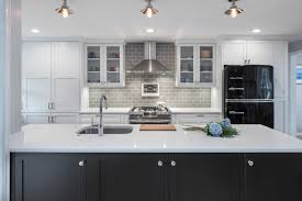 The use of polished nickel hardware and pendants adds a bright touch. Modern Farmhouse Kitchen With Black Island Crystal Cabinets