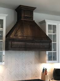 A typical metal hood can detract from a kitchen's appearance, especially if you are trying to showcase beautiful wood cabinets. Kitchen Range Hood Made Out Of Reclaimed Barn Wood