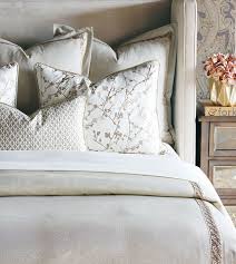 Cloud wallpaper accents the ceiling of this welcoming bedroom featuring a gold rattan bed dressed in white and blue bedding and flanked by light gray nightstands lit by aerin keil swing arm wall lights and a brass semi flush mount. Balfour Collection Eastern Accents