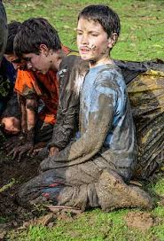A group of children playing in the mud. Scouts child game.