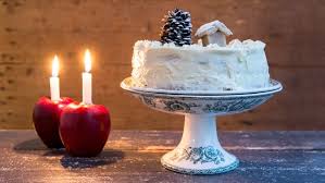 Eine Mit Creme Verzierte Torte Steht Auf Einer Porzellanplatte Daneben Zwei Brennende Kerzen Die In Apfeln Stecken Rezepte Kochen Torten