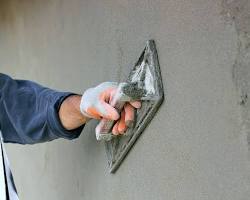 штукатур, що наносить штукатурку на стіну